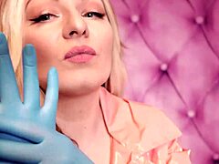 Aria Grander, en forførende MILF, bærer en fetichistisk påklædning, herunder en lyserød PVC-frakke og blå nitrilhandsker, der viser sine fantastiske kurver i denne hjemmelavede video