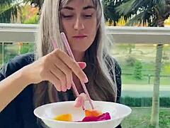 Ένα εντυπωσιακό μοντέλο επιδεικνύει τα chopsticks και τα εξωτικά φρούτα της με σαγηνευτική ενδυμασία
